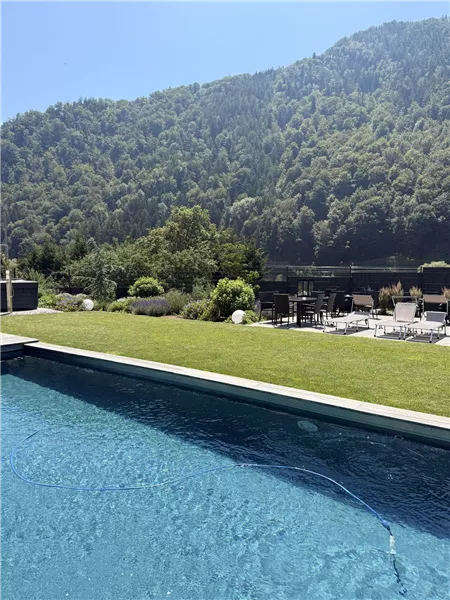 Naturpool mit Rasenfläche vor Bergkulisse in Übelstein