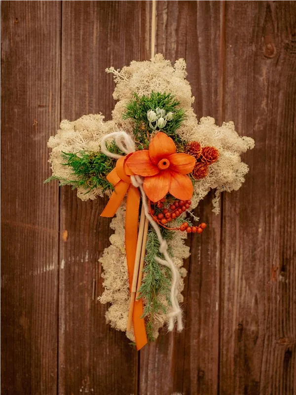 Grabkreuz aus Moos mit orangen Blüten und Bändern